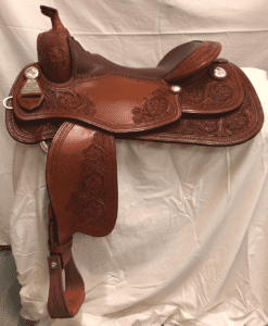 A saddle that is sitting on top of a white cloth.