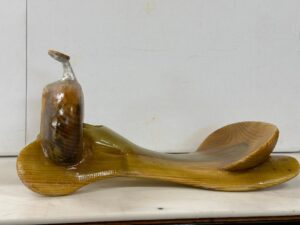 A wooden spoon and bowl on top of a counter.